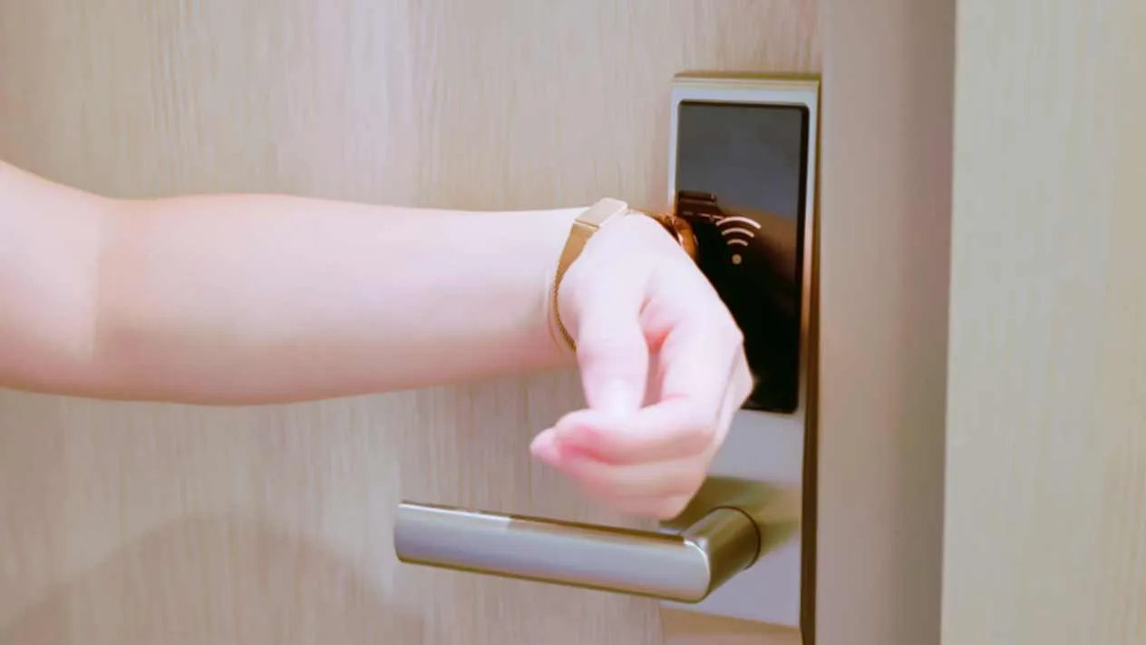 Kobieta otwiera drzwi z zamkiem NFC