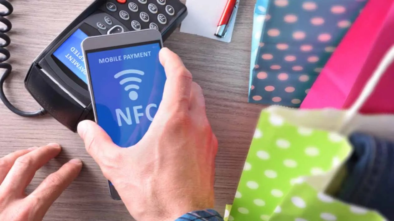 Klient płaci w sklepie telefonem z technologią NFC